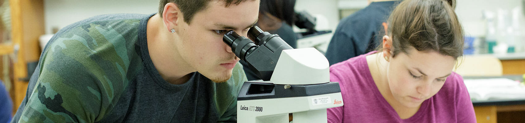 Male student looking through telescope