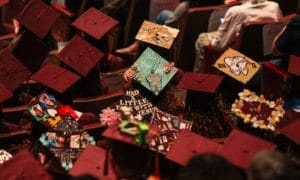 Jackson College students at commencement showing the top of their graduation caps decroated.