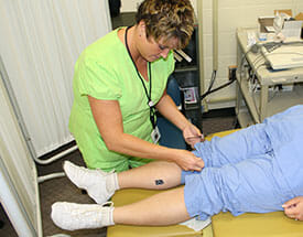 EKG Technician performing procedure on patient