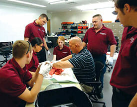 instructer teaching students around a stretcher