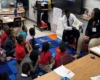 male student reading to children