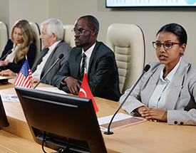 three people talking in board room setting