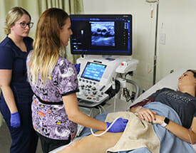 Female student standing next to ultrasound machine