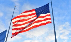 American flag blowing in the wind in the sky.