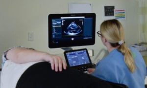 Student performing an ultrasound scan using sonography equipment