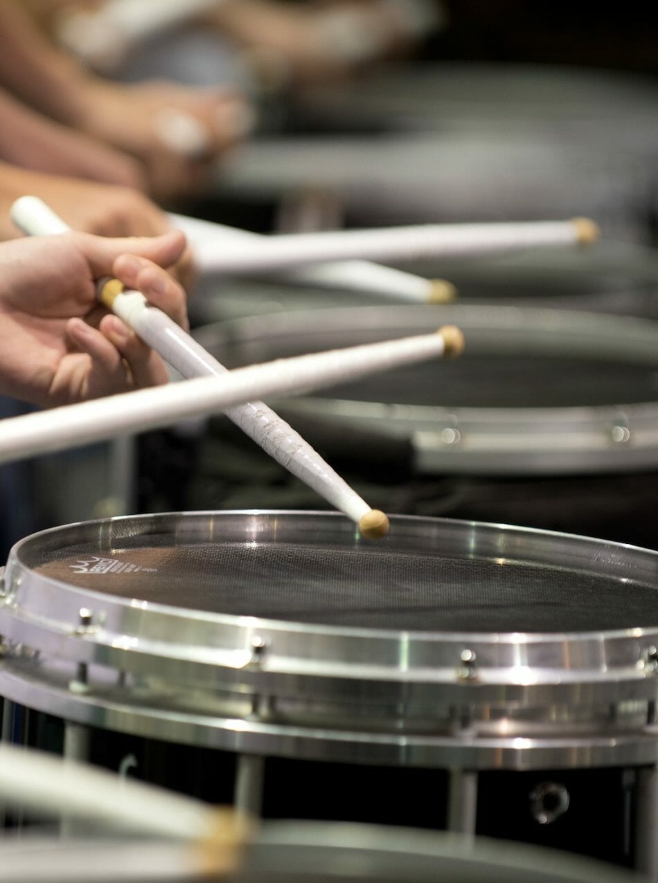 drummers in row playing drums