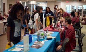 A group of current and potential students of Jackson College learning more about local vendors and what Jackson College has to offer at tables set up at the Great Day to be a Jet Open House.
