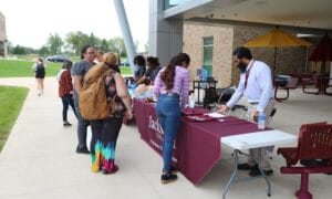 Students looking at tables set up of different departments and community resources at the Jackson College Jet Jam.