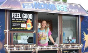 A female worker ready to serve ice cones in the Kona Ice food truck.