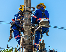 line workers in buckets at utility pole