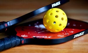 close up photo of pickleball racket and ball.