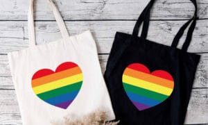 Tote bags with pride rainbow hearts on them.