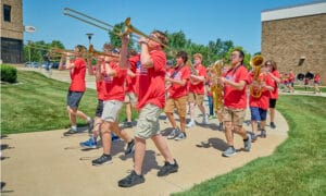 Band performers marching in a parade playing their instruments.